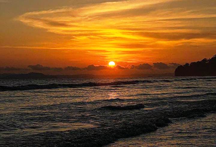 ropical beach at Kalipur, North Andaman, dark green forest meeting pale sand, a rocky shoreline, Quiet forest-lined Kalipur Beach near Diglipur where sea turtles nest in winter