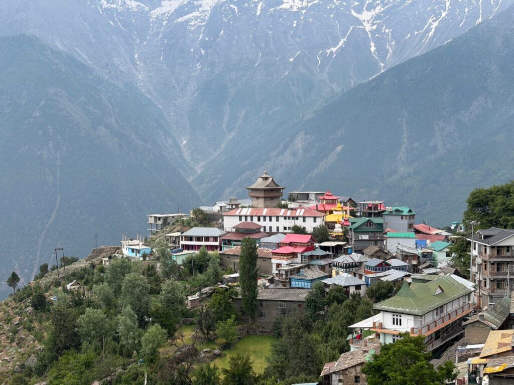 Charming village of Kalpa nestled in the majestic Himalayas under a bright day sky. Places to visit in Kalpa village with Kinner Kailash range in the background