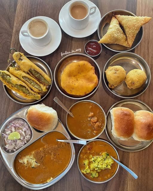 Morning scene at a traditional Panaji breakfast eatery. Plates of puri bhaji and Goan buns on a simple table, steel glasses of tea, warm morning light through a window. Vegetarian breakfast in Panaji, a classic stop among pure veg and Jain restaurants in Goa