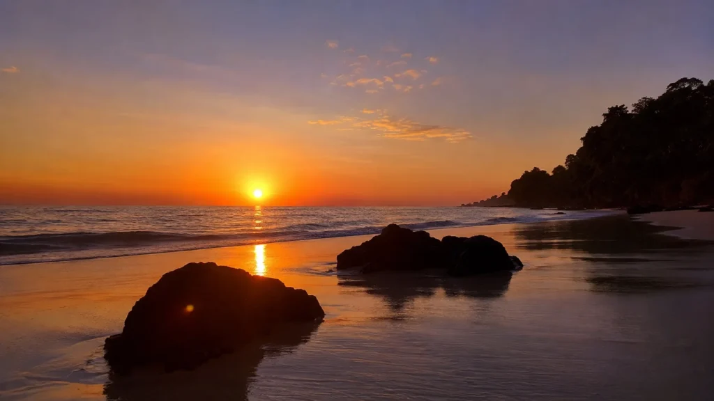 Sunrise over Kalapathar Beach Havelock with black rocks on pale sand