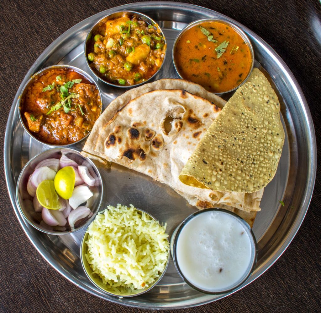 Enjoy a delicious Indian thali showcasing traditional cuisine with various dishes. Vegetarian thali, a typical meal at pure veg and Jain restaurants in Goa